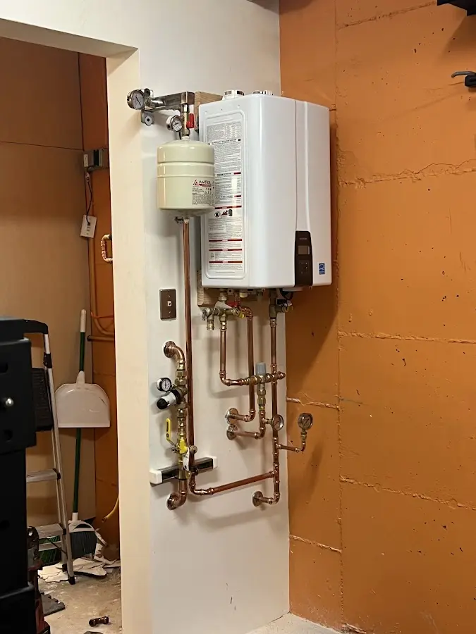 Plumbing technician inspecting water heater connections in Marion